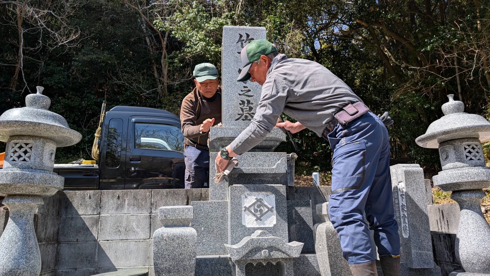 [画像]お墓を拭き清める作業員